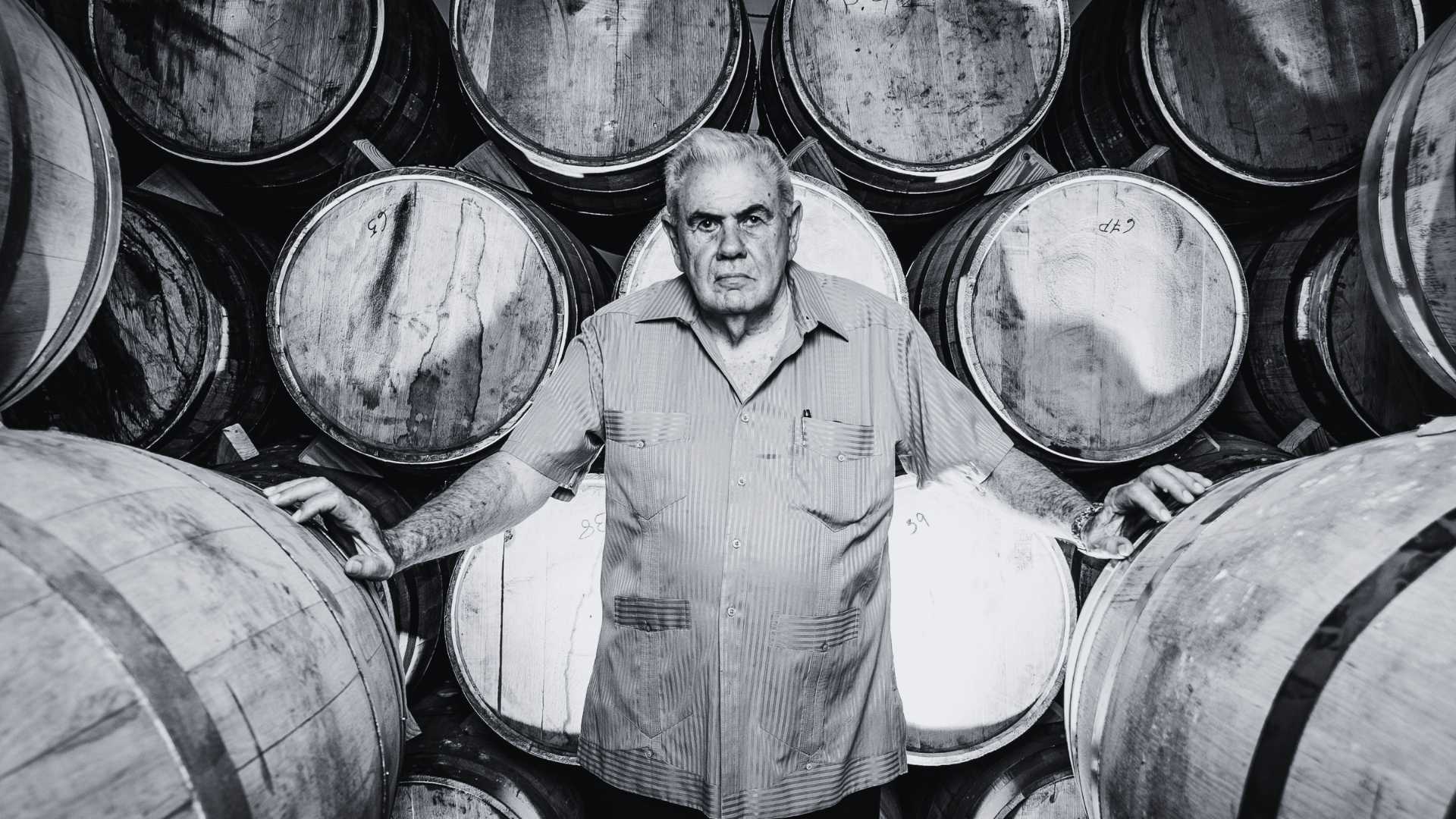 Don Pancho standing among the aging barrels